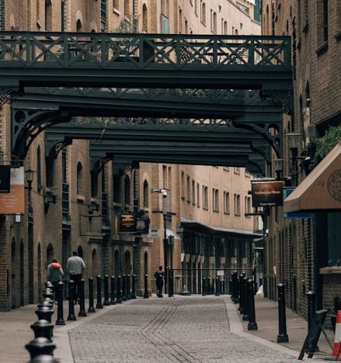 Industrial Style - A picturesque cobblestone alleyway with historic architecture in London's city center, featuring overhead walkways.