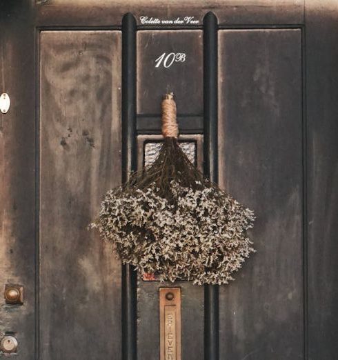 Eclectic Decor - Classic black door with wreath against brick house. Cozy and inviting entrance.