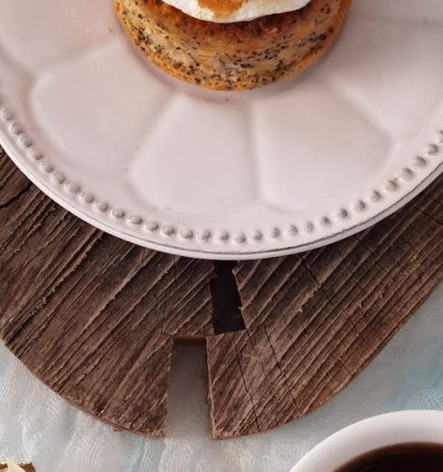 Cottagecore - Top view of a frosted cupcake on a rustic tray with a cup of coffee, surrounded by delicate decor.