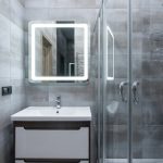 Shower Doors - Contemporary washbasin under mirror against shower room with glass walls and tiles at home