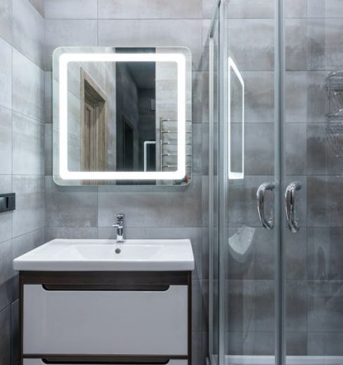 Shower Doors - Contemporary washbasin under mirror against shower room with glass walls and tiles at home