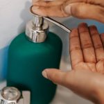 Touchless Faucets - Person using faucet with soap in bathroom