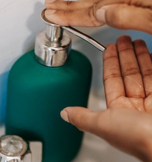 Touchless Faucets - Person using faucet with soap in bathroom