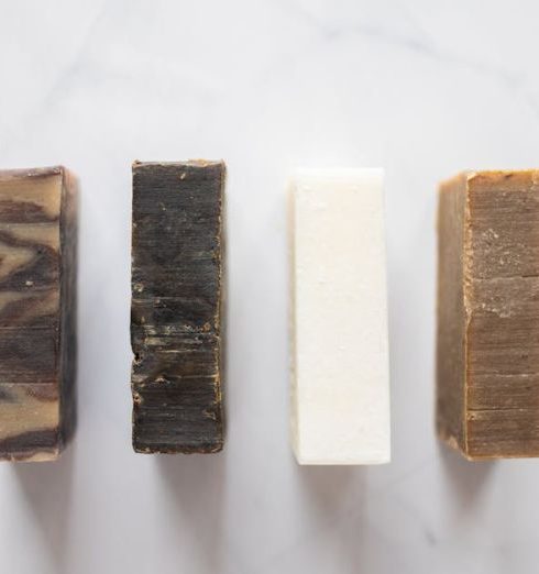 Bathroom Color - Top view of composition with handmade aromatic soap placed on white background in bathroom