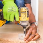 Flooring - Person Using Dewalt Cordless Impact Driver on Brown Board