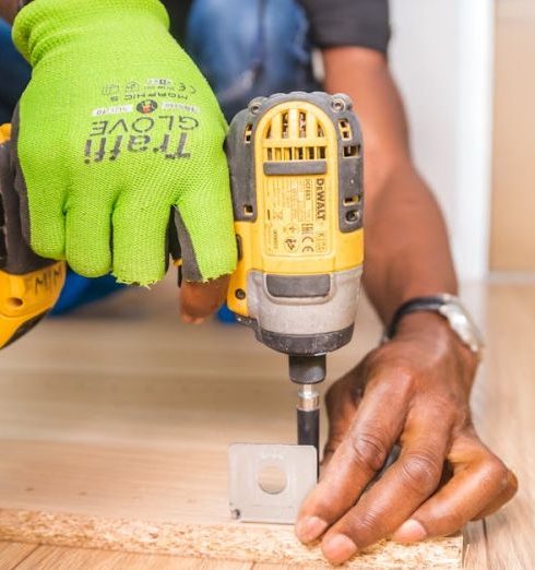 Flooring - Person Using Dewalt Cordless Impact Driver on Brown Board