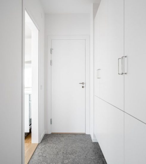 Mudroom - a long hallway with white walls and doors