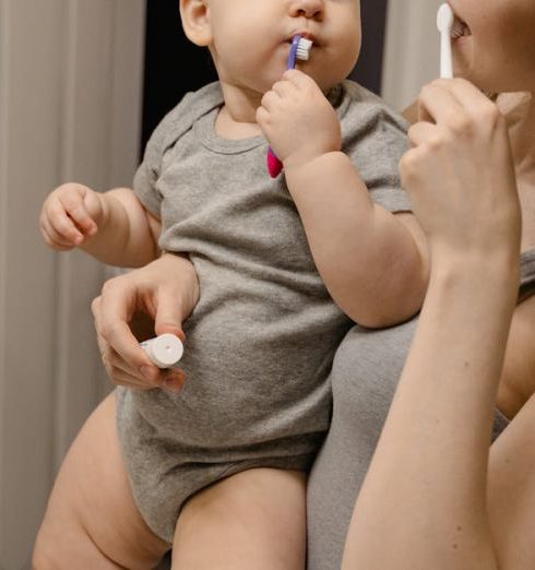 Washing Station - Photo of a Mother Brushing Her Teeth with Her Baby