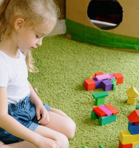 DIY Toys - A Girl in White Shirt Playing with Colorful Wooden Blocks on the Carpet