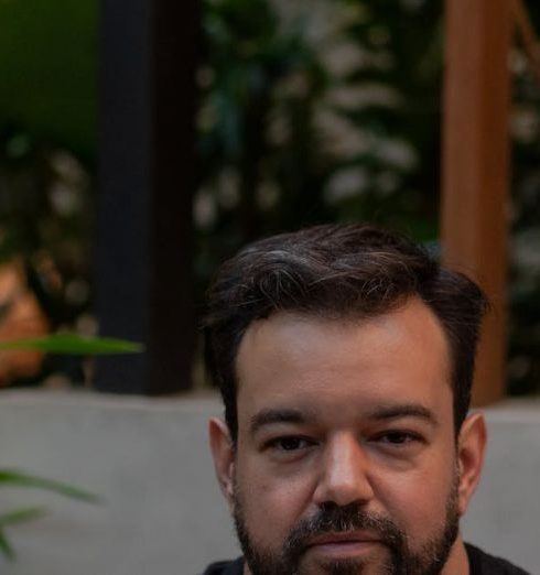 Contemporary Furniture - Man sitting with laptop in a serene indoor garden, focusing on work.