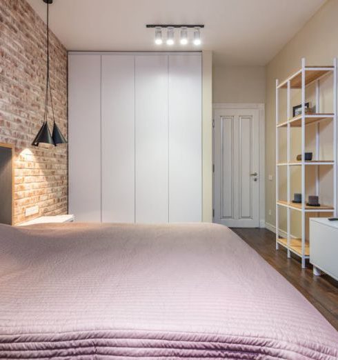 Transitional Furniture - Bed with cover under empty panel on brick wall against television with black screen above cabinet at home