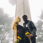 Year-Round Landscape - Photo of Man and Woman Standing Beside Cross Monument