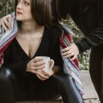 Legal Steps - A woman comforts another on outdoor steps with a supportive gesture.