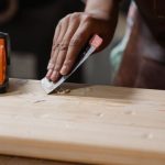 Tools - Hands crafting a wooden plank with clamps and tools. A focus on precision woodworking.