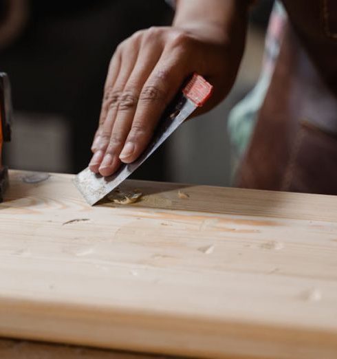 Tools - Hands crafting a wooden plank with clamps and tools. A focus on precision woodworking.