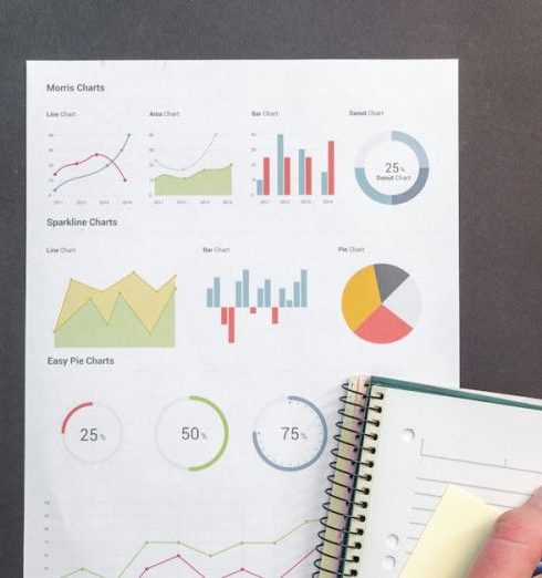 Market Research - Overhead view of a business desk with charts and a laptop, ideal for data analysis concepts.