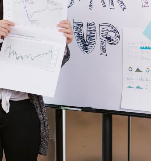 Crowdfunding - A young woman gives a startup presentation with charts and graphs on a flipchart.