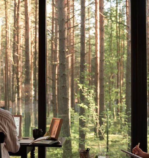 Freelancers - A man and woman working from home in a scenic cabin surrounded by forest.