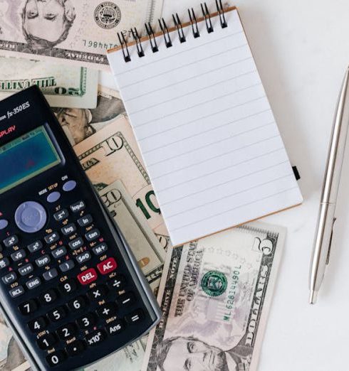 Budget - Flat lay of US dollar bills with calculator and notebook for budgeting.