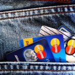 Credit Score - Close-up of a denim pocket with multiple credit cards, illustrating finance and fashion.