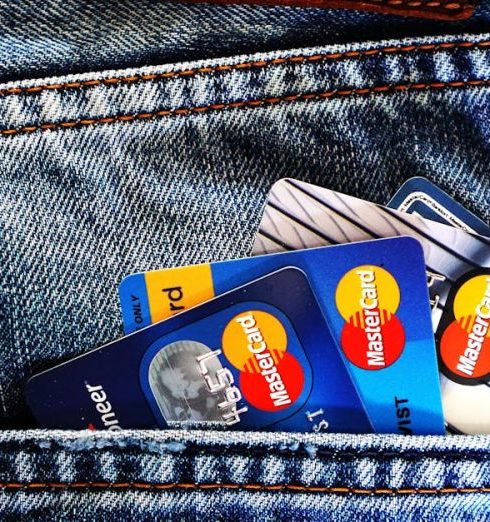 Credit Score - Close-up of a denim pocket with multiple credit cards, illustrating finance and fashion.