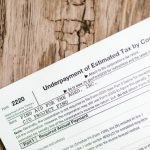 Business Taxes - Close-up of a corporate tax form on a textured wooden surface, highlighting document details.