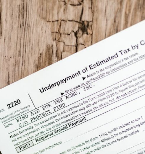 Business Taxes - Close-up of a corporate tax form on a textured wooden surface, highlighting document details.