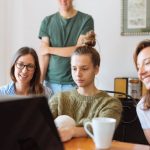 Webinars - A diverse group of adults at work, enjoying a casual meeting indoors with focus and smiles.