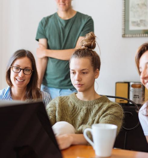 Webinars - A diverse group of adults at work, enjoying a casual meeting indoors with focus and smiles.