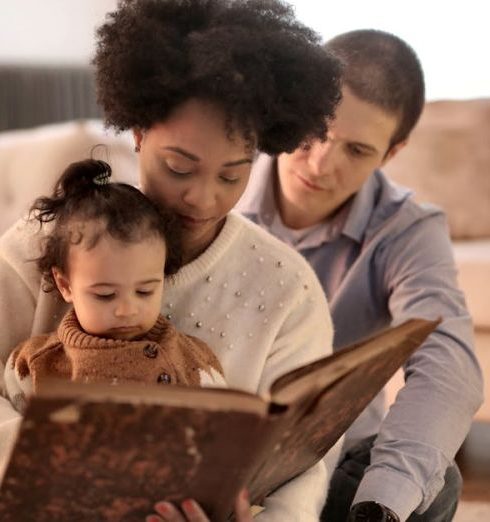 Storytelling - Mother, father, and child enjoying a storybook together in their cozy living room.