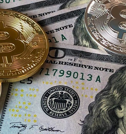 Affiliate Marketing - A close-up photo depicting Bitcoin coins on top of US dollar bills, symbolizing finance and cryptocurrency.