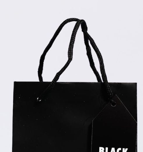 Brand Awareness - Minimalist black shopping bag with Black Friday tag, perfect for holiday sales themes.