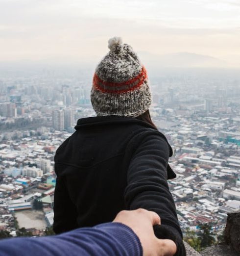 Trust - A couple holding hands overlooking a vast urban cityscape, emphasizing travel and togetherness.