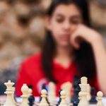 Decision Making - Child deeply focused on a strategic chess game outdoors in Turkey.