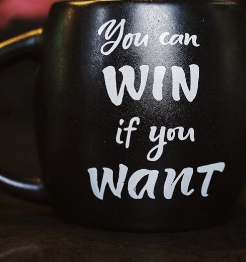 Motivation - Black mug with inspirational quote 'You can win if you want' reflected on a dark surface, creating a motivational ambiance.