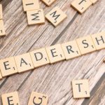 Leading By Example - Wooden letter tiles spelling 'LEADERSHIP' on a wooden surface, symbolizing leadership qualities and skills.