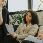 Active Listening - Three professional women engaged in a collaborative meeting in a modern office setting.