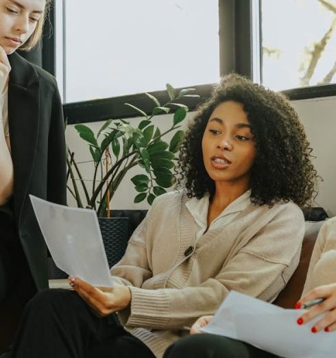 Active Listening - Three professional women engaged in a collaborative meeting in a modern office setting.