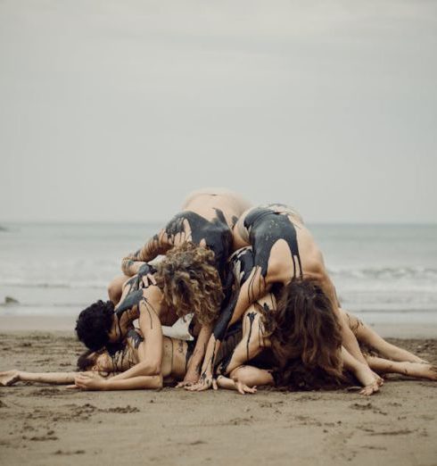 High-Performing Team - A group of environmental activists create a dramatic performance on a sandy beach, symbolizing oil pollution.