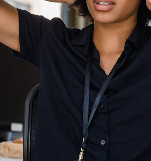 Conflict Management - Young businesswoman looking stressed at her desk in a modern office.