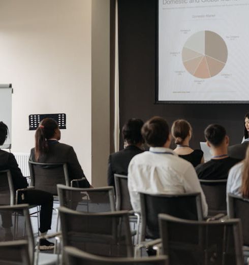 Market Share - Business professionals attending a seminar with a presentation on market share, highlighting diverse participation.