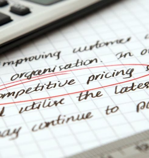 Pricing - Focused image of handwritten business notes with calculator emphasizing pricing strategy.