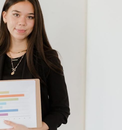 Growth Marketing - Confident businesswoman presenting a colorful bar graph on a clipboard.