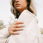 Scalable Model - Young woman posing outdoors in white shirt against a natural backdrop.