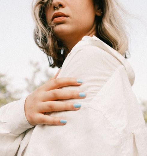 Scalable Model - Young woman posing outdoors in white shirt against a natural backdrop.