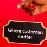 Customer Value - A hand holding a sign with the text 'Where customers matter' against a red background.