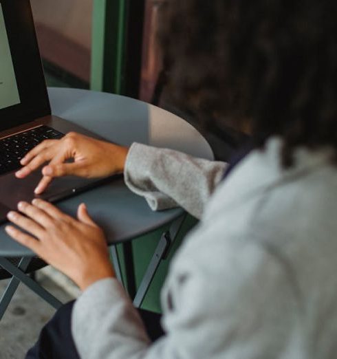 Sales Funnel - A woman working remotely on a laptop at an outdoor café table, focusing on a sales funnel diagram.