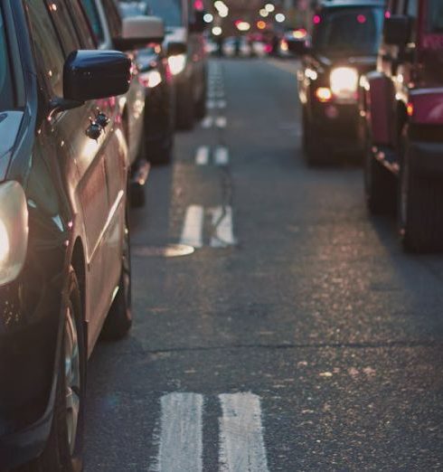 Traffic - A congested city street lined with cars stuck in traffic at dusk, showcasing urban life.