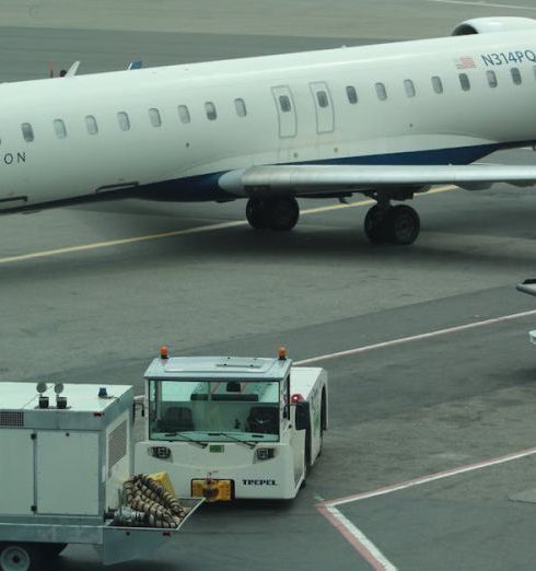 Operational Efficiency - Delta Connection airplane on airport tarmac with service vehicles preparing for takeoff.