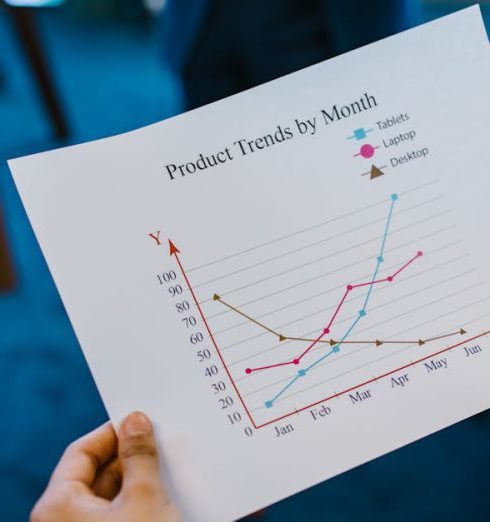 Product Launch - Close-up of hands holding a product trend chart in a corporate office setting.